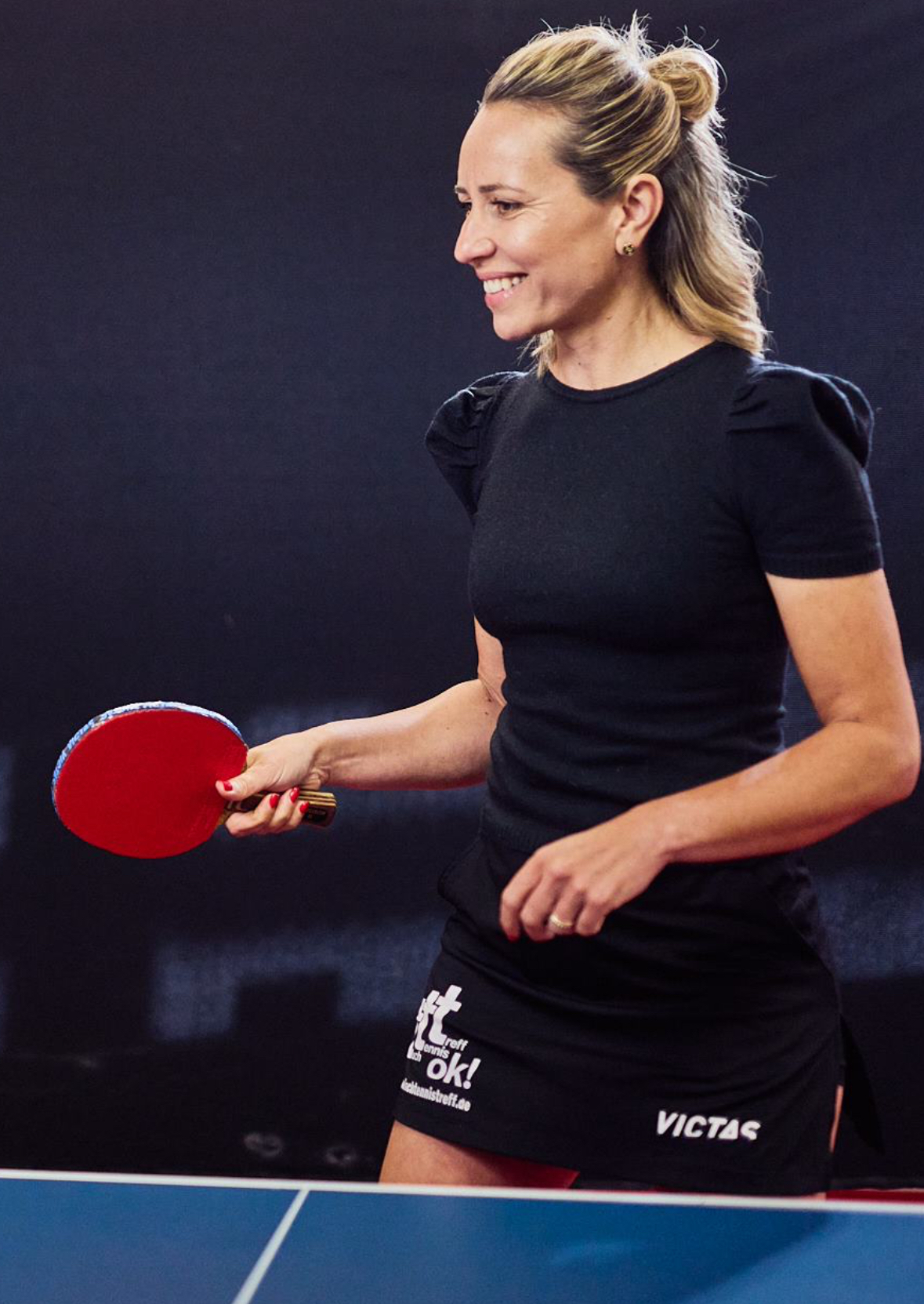 Olga Koop mit Tischtennisschläger am Tisch